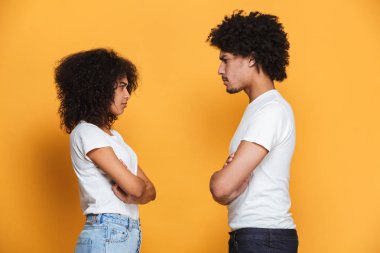 Üzgün bir afro Amerikan Çift sarı arka plan üzerinde izole bir tartışmayı portresi