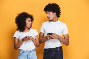 Cep telefonu sarı arka plan izole karışık bir afro Amerikan çiftle portresi