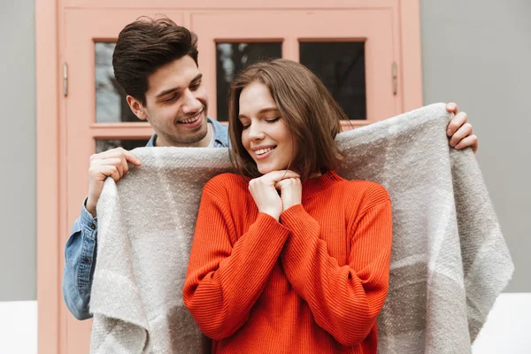 Photo Smiling Couple Standing Man Wrapping His Woman Warm Blanket — Stock Photo, Image