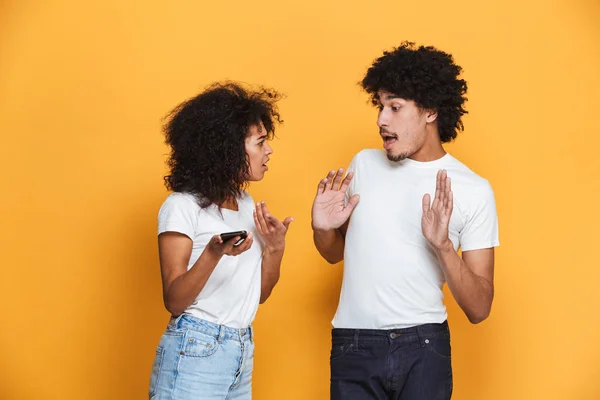 Retrato Una Joven Pareja Afroamericana Discutiendo Por Teléfono Móvil Aislado —  Fotos de Stock