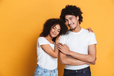 Sarı arka plan üzerinde izole mutlu afro Amerikan çifte sarılma portresi