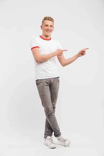Full Length Portrait Smiling Teenage Boy Pointing Copy Space Isolated — Stock Photo, Image