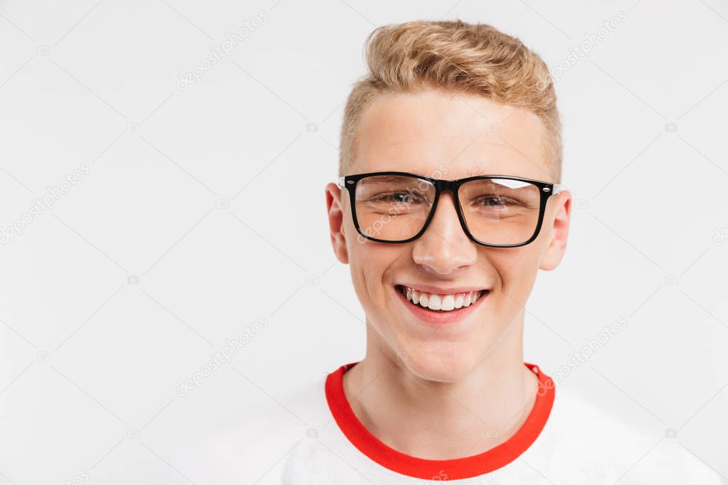 Image closeup of blond student boy having clean healthy skin wearing eyeglasses smiling at camera with white teeth isolated over white background