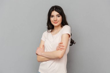 Neşeli güzel genç bayan gri arka plan duvardan izole ayakta görüntüsünü.