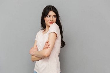 Neşeli güzel genç bayan gri arka plan duvardan izole ayakta görüntüsünü.