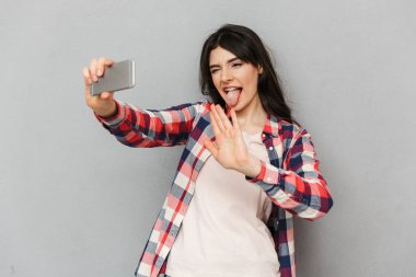 Selfie tarafından cep telefonu konuşan arkadaşlar sallayarak yapmak imge-in sevimli komik genç bayan gri arka plan duvardan izole.
