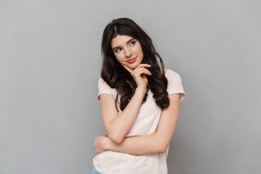 Şirin düşünme genç bayan gri arka plan duvar bir yana bakmaktan izole ayakta fotoğrafı.