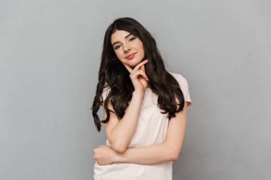 Neşeli güzel genç bayan gri arka plan duvardan izole ayakta görüntüsünü.