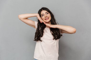 Sevimli güzel genç bayan gri arka plan duvardan izole ayakta görüntüsünü.