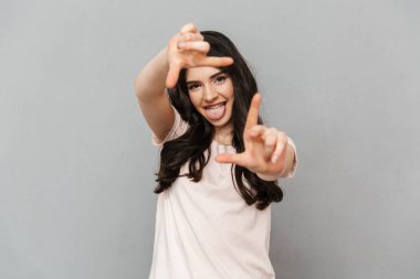 Sen fotoğraf çekme gri arka plan duvar üzerinde izole gibi elleriyle işaret bir atış almak duygusal genç bayan fotoğraf.