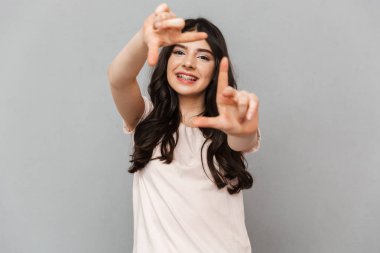 Sen fotoğraf çekme gri arka plan duvar üzerinde izole gibi elleriyle işaret bir atış almak duygusal genç bayan fotoğraf.