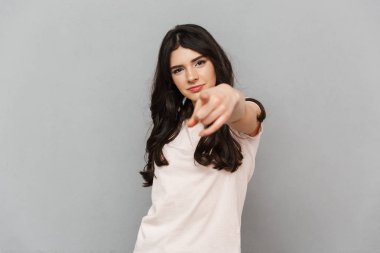 Güzel genç bayan için işaret gri arka plan duvar üzerinde izole ayakta görüntüsünü.