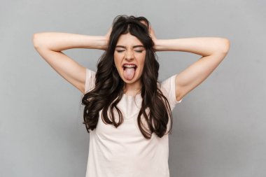 Sevimli güzel genç bayan gri arka plan duvar çığlık içinde izole ayakta fotoğrafı.