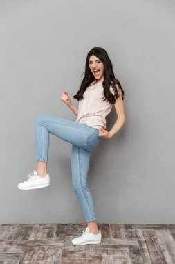 Gri arka plan duvardan izole kazanan jest yapmak imge-in duygusal genç bayan.