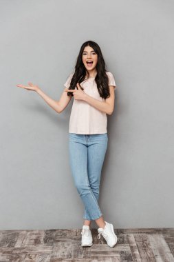 Duygusal genç bayanın boşaltmak gri arka plan duvardan izole gösteren resim.