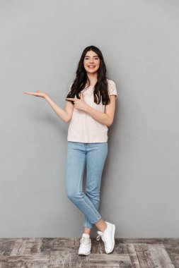 Duygusal genç bayanın boşaltmak gri arka plan duvardan izole gösteren resim.