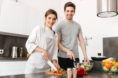 Oldukça genç bir çift birlikte mutfakta yemek portresi