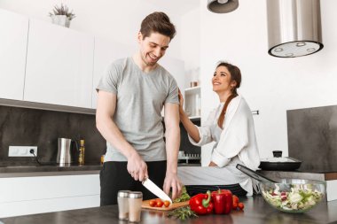 Neşeli bir genç çiftin birlikte mutfakta yemek portre