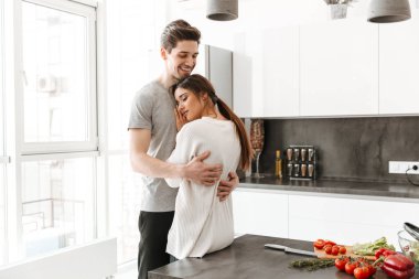 Evde mutfak mutlu bir genç çifte portresi sarılma