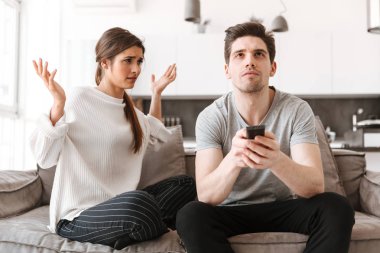 Tv izlerken erkek arkadaşıyla bir kanepede oturan genç bir kadın portresi