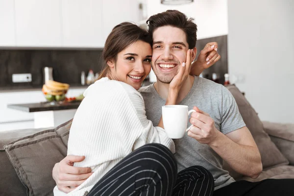Portrait Lovely Young Couple Drinking Coffee While Sitting Couch Kissing — Stock Photo, Image