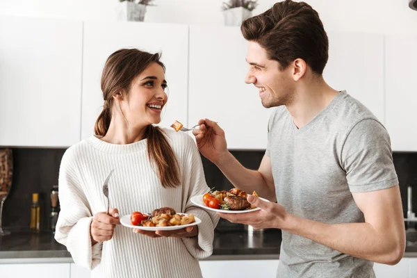 Portrait Loving Young Couple Holding Dinner Plates Food While Standing — Stock Photo, Image