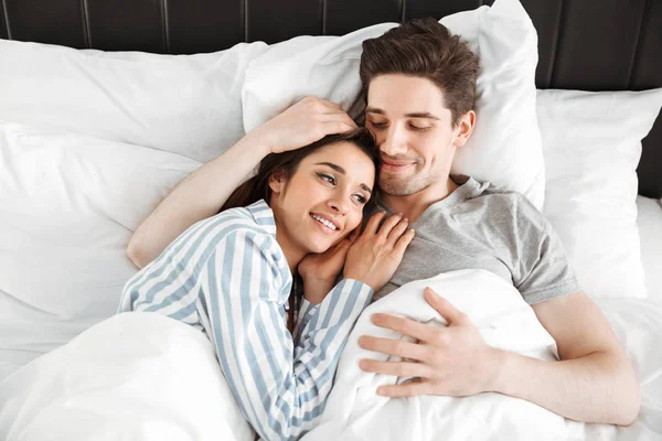 Πορτρέτο Του Ένα Happy Νεαρό Ζευγάρι Ξαπλωμένο Μαζί Στο Κρεβάτι — Φωτογραφία Αρχείου