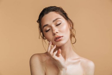 Genç ve güzel bir üstsüz kadın gözleri ile poz güzellik portresi bej renkli arka plan üzerinde izole kapalı