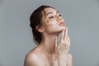 Yumuşak sağlıklı deri ve gri arka plan bir kenara inceliyorlar izole altın makyaj ile esmer kadın güzellik fotoğrafı.