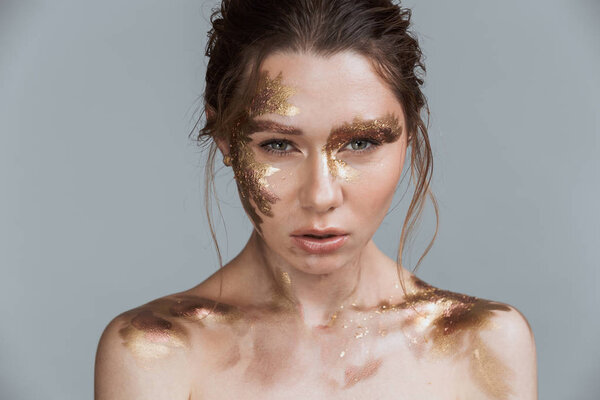 Красота фото привлекательной брюнетки женщина с мягкой здоровой кожей и золотой макияж изолированы на сером фоне глядя камеры
.