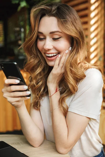 Close Retrato Uma Menina Sorrindo Olhando Para Telefone Celular Enquanto — Fotografia de Stock