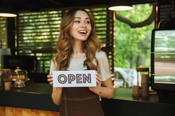 Retrato Una Joven Barista Alegre Delantal Sosteniendo Cartel Abierto Mientras —  Fotos de Stock