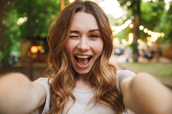 Parkta bir selfie duran uzanmış el ile alarak oynak genç kızın yakın çekim