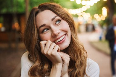 Sevimli Genç kız parkta dururken kamera bakıyor, yakın çekim