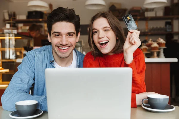 Emocionada Pareja Joven Mostrando Tarjeta Crédito Sentado Mesa Cafetería Con — Foto de Stock