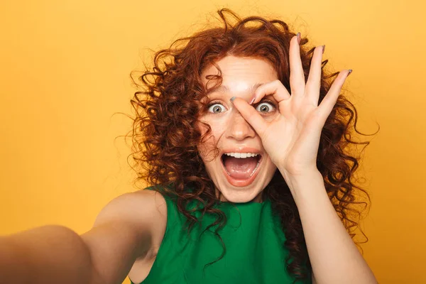 黄色背景に分離された Selfie を取ってのドレスで幸せな赤毛の女性の肖像画間近します — ストック写真