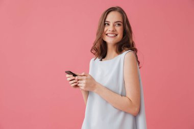 Duran bir yana telefonla sohbet arıyorsunuz pembe bir arka plan üzerinde izole mutlu genç kadın görüntüsünü.