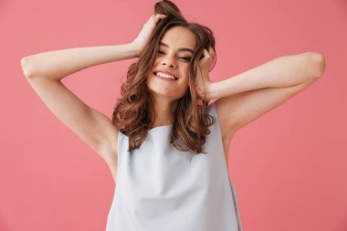 Görüntü izole kamera seyir pembe arka plan üzerinde duran neşeli genç kadın.