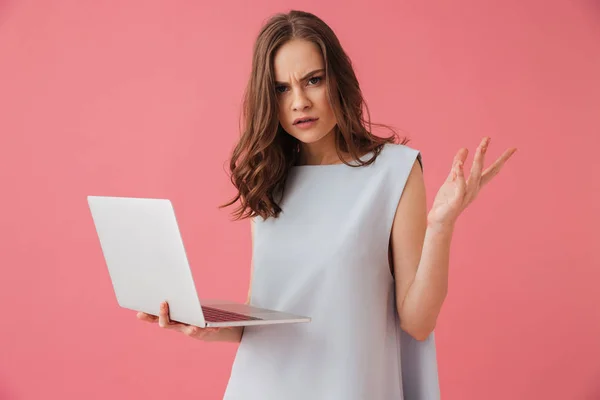 Imagem Jovem Mulher Confusa Isolado Sobre Fundo Rosa Usando Computador — Fotografia de Stock