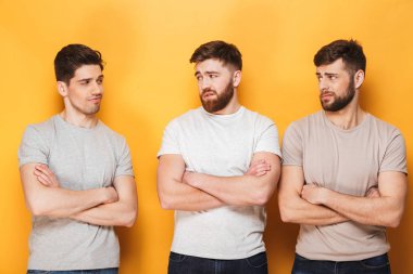 İki genç hayal kırıklığına adam sarı arka plan üzerinde izole onların erkek arkadaşı bakarak