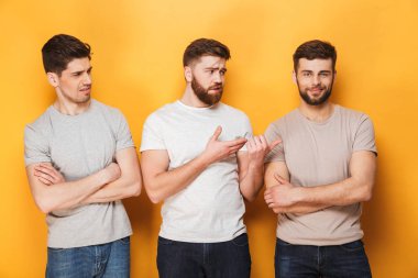 İki genç erkek sarı arka plan üzerinde izole onların erkek arkadaşı bakarak üzgün
