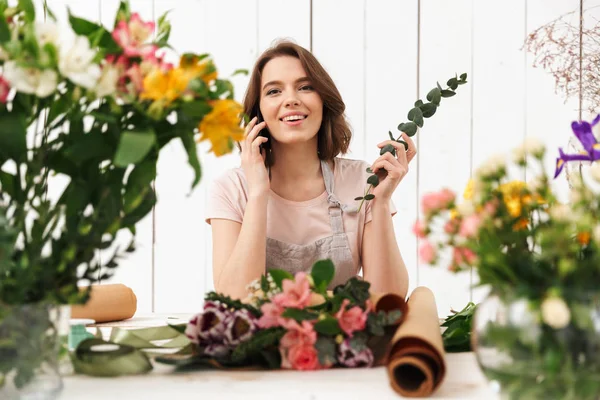 Young Cute Florist Woman Standing Lot Flowers Workshop Talking Mobile — Stock Photo, Image