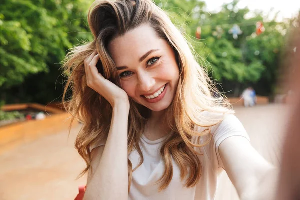 Açık havada selfie uzanmış el ile alarak genç ve güzel bir kız yakın çekim