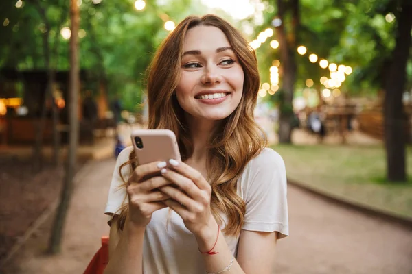 Elégedett Fiatal Lány Gazdaság Mobiltelefon Állva Parkban — Stock Fotó