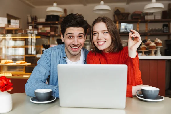 Feliz Joven Pareja Mostrando Tarjeta Crédito Sentado Mesa Cafetería Con — Foto de Stock