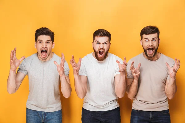 Tres Jóvenes Hombres Enojados Gritando Aislados Sobre Fondo Amarillo —  Fotos de Stock