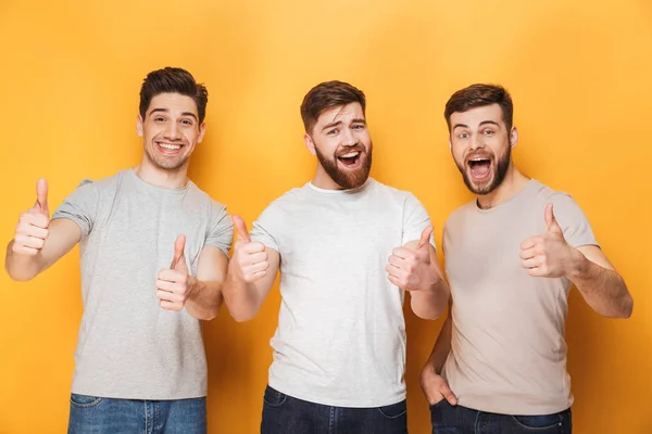 Three Young Excited Men Showing Thumbs Isolated Yellow Background — Stock Photo, Image