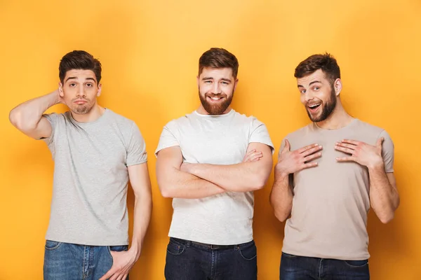 Drei Junge Verwirrte Männer Blicken Vereinzelt Die Kamera Vor Gelbem — Stockfoto