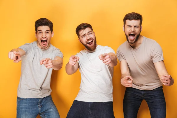 Three Young Happy Men Pointing Camera Screaming Isolated Yellow Background — Stock Photo, Image