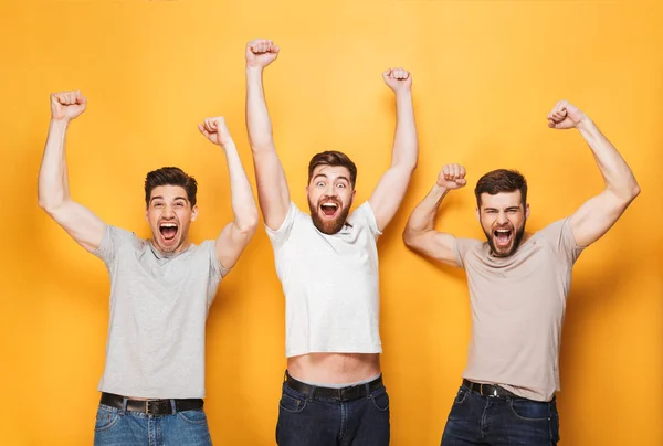 Three Young Excited Men Celebrating Success Screaming Isolated Yellow Background — Stock Photo, Image